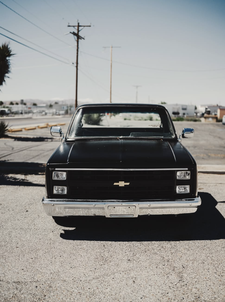 Front view of a black square body Chevy pickup