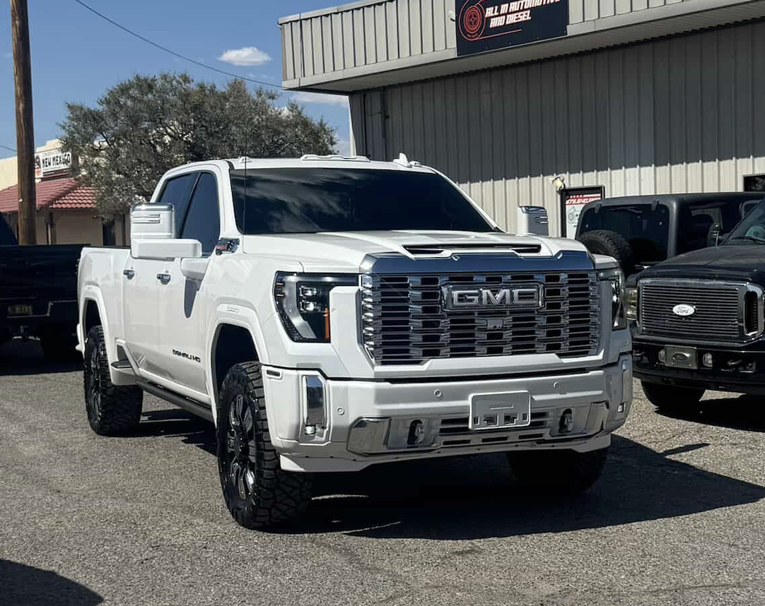 White GMC Denali HD truck with a flawless factory-quality finish outside the shop